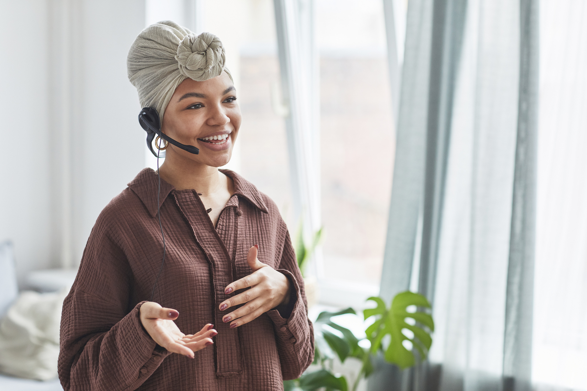 Smiling black operator in headset speaking